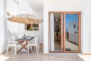 comedor con mesa y sombrilla en Modern house in Puerto del Carmen, en Tías