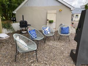 un grupo de sillas sentadas frente a una parrilla en Lemonade cottages, en Kilmurry McMahon