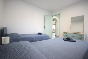 a bedroom with two beds and a mirror and a chalkboard at Villa Il Melograno in Tortolì