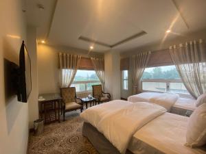 a hotel room with two beds and a window at Sintra Hotel in Islamabad