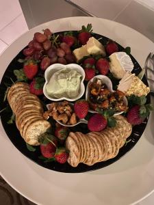 a plate of food with meat and cheese and strawberries at Spa Suites at RAVEN in Hepburn Springs