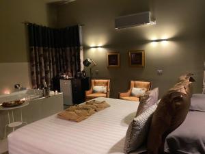 a bedroom with a large bed with two chairs at Spa Suites at RAVEN in Hepburn Springs +37 photos