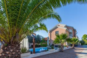 una casa con palmeras y piscina en Villa Julian en Zadar