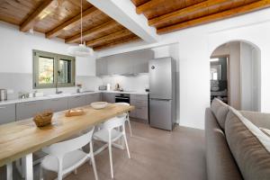a kitchen with a wooden table and a dining room at Etesian Villas in Batsi