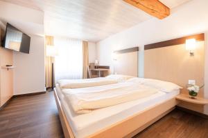 ein Schlafzimmer mit einem großen weißen Bett in einem Zimmer in der Unterkunft Hotel zum goldenen Kreuz in Frauenfeld