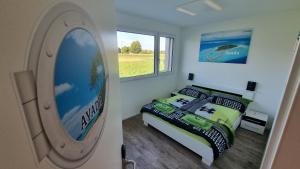 um quarto com uma cama e uma grande janela em BeachIN - Sport, Events, Hotel, Restaurant, Bar em Ins