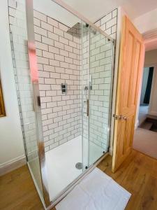 a shower with a glass door in a bathroom at Beautiful 2 bed end terrace Victorian town house in Redruth