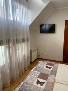 a bedroom with a bed and a flat screen tv at Willa Bursztyn Gdansk in Gdańsk