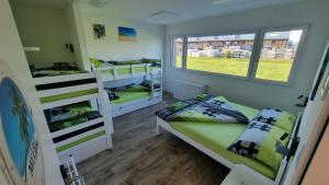 um quarto com 2 beliches e 2 janelas em BeachIN - Sport, Events, Hotel, Restaurant, Bar em Ins