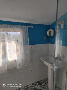 La salle de bains est pourvue d'une douche et d'un lavabo. dans l'établissement Agua de mayo, à Hinojales