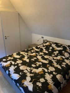 una camera con un letto con una coperta bianca e nera di Maison Napoleon a Malmedy