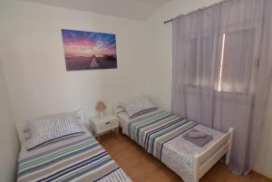 two twin beds in a room with a window at Holiday home Tcono in Tkon