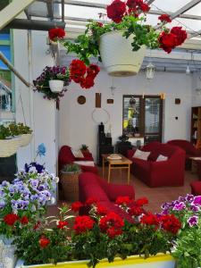 a living room filled with lots of red couches and flowers at Villa Vraji in Hrabušice