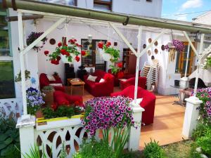 a patio with red couches and flowers on it at Villa Vraji in Hrabušice