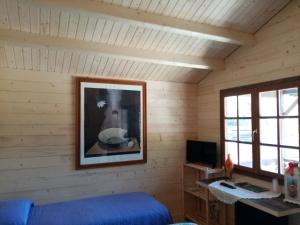 una camera con un letto e una foto appesa al muro di Agriturismo Rosso Lampone a Cerreto Laziale