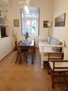 a living room with a white couch and a table at Hydra Memories House in Hydra