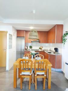 a kitchen with a wooden dining room table and chairs at Almar Carril in Vilagarcia de Arousa