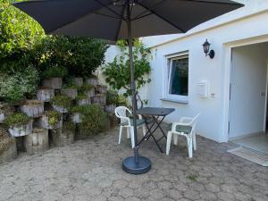 einen Tisch mit 2 Stühlen und einem Sonnenschirm auf einer Terrasse in der Unterkunft Ferienwohnung Löwenzahn in Fischingen