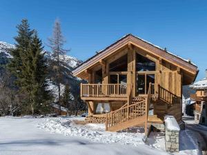 a log cabin in the snow with a porch at Chalet moderne à Méribel avec jacuzzi et sauna - FR-1-566-30 in Les Allues
