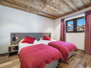 1 Schlafzimmer mit 2 Betten mit roten Kissen und einem Fenster in der Unterkunft Chalet Méribel, 7 pièces, 12 personnes - FR-1-566-30 in Les Allues