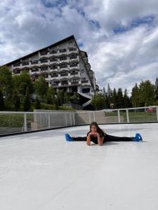 a young girl laying on the ground on a skate park at Hotel Pestera in Sinaia