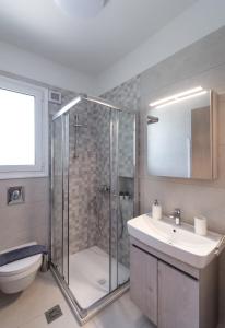 y baño con ducha, lavabo y aseo. en Memoria Apartments by Imagine Lefkada en Lefkada