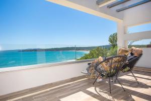 a man and two children sitting in a chair in front of a window at Olive Villas Beach Hotel in Sozopol