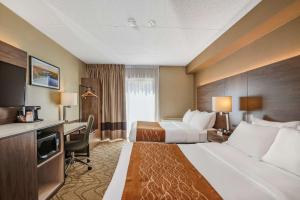 a hotel room with two beds and a desk at Comfort Inn Lakeshore in North Bay