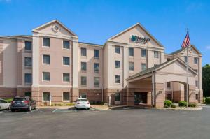 a hotel with cars parked in a parking lot at MainStay Suites Airport in Roanoke