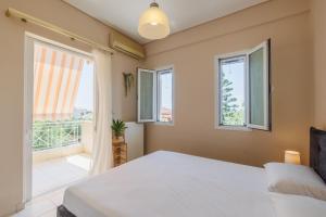 a bedroom with a bed and a large window at Paralia Vergas Apartments in Verga Kalamata