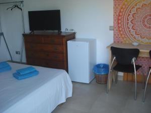 a bedroom with a bed and a dresser with a television at Villa Romaní SUITE in Son Carrio