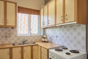 a kitchen with a white stove and a sink at Paralia Vergas Apartments in Verga Kalamata +37 photos