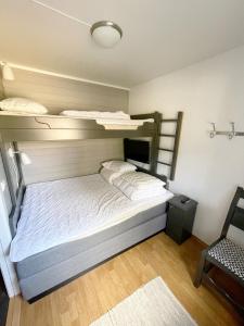 a bedroom with two bunk beds and a chair at Experience Tranquility - Your Ideal Apartment Retreat in Uvdal, at the Base of Hardangervidda in Uvdal