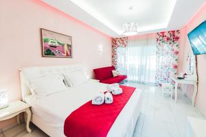 ニキティにあるDream Boutique Apartmentsのベッドルーム(白いベッド1台、赤い毛布付)