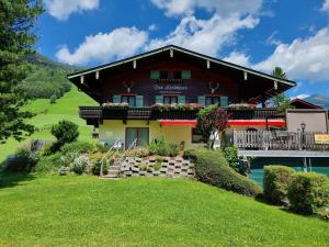 ein Haus auf einem Hügel mit einem grünen Hof in der Unterkunft Das Landhaus in Gerlos