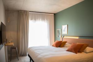 - une chambre avec un grand lit et une grande fenêtre dans l'établissement Campanile Saint Brieuc - Centre Gare, à Saint-Brieuc
