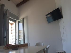 comedor con mesa y TV en la pared en LAREROOMS 2, en Mérikhas