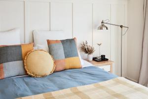 a bed with colorful pillows and a lamp on it at Crittenden Lakeside Villas in Dromana