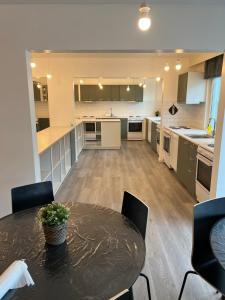 a large kitchen with a black table and chairs at Noah Longstay in Västerås