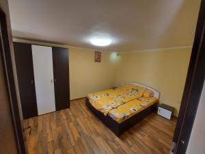 a bedroom with a bed with a yellow comforter at Casa de vacanta in Tara Fagarasului in Beclean
