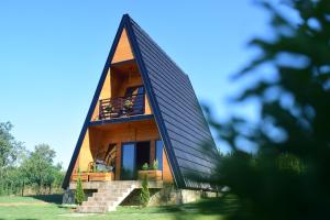 a small house with a triangular roof on a field at Vila Grujic in Vrdnik
