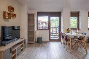 a kitchen and dining room with a table and a television at Tarnovgrad Apartments - Free parking in Veliko Tŭrnovo