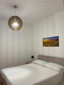 una camera con un letto bianco e un dipinto sul muro di Nova Lux a Custonaci