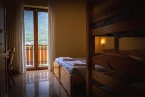 a bedroom with a bed and a window with a balcony at Agriturismo la campagnola in Gordona