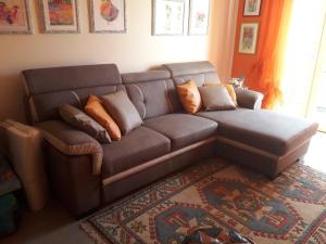 un sofá marrón con almohadas en la sala de estar en Casa Zen by Mary, en Rivoli