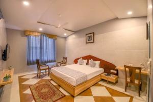 una camera da letto con un letto, un tavolo e delle sedie di Gems Suites-A Boutique Stay a Jaipur