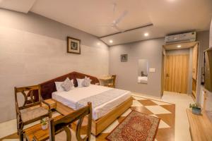 1 dormitorio con 1 cama y 1 silla en Gems Suites-A Boutique Stay en Jaipur