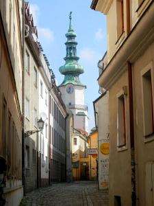 un callejón con una torre de reloj en la distancia en Apartment Kate - Old Town en Bratislava
