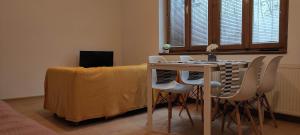 uma mesa de jantar com cadeiras brancas e um lençol amarelo em Apartment Kate - Old Town em Bratislava