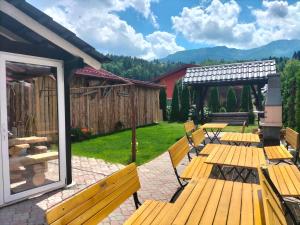 a group of benches sitting on a patio at Pensiune Stirbu in Borsa